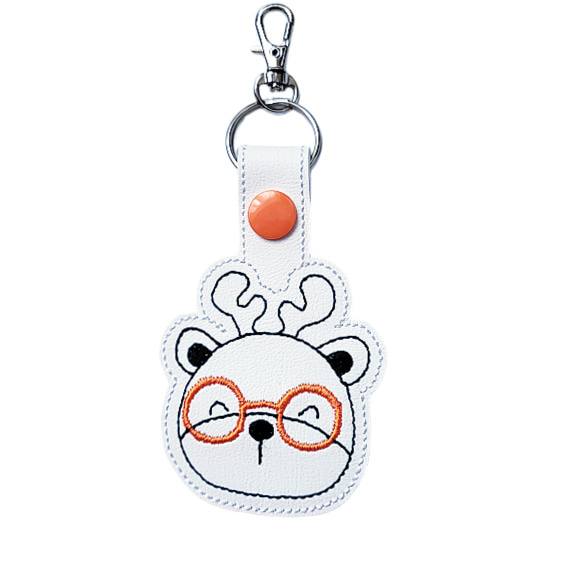 Deer face keyring with orange glasses, made from white faux leather with a metal split ring and swivel clasp.
