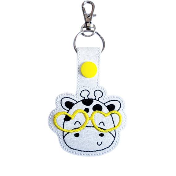 Giraffe face keyring with yellow glasses, made from white faux leather with a metal split ring and swivel clasp.