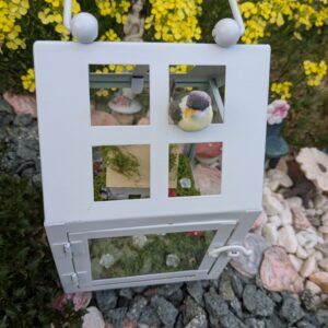 Fairy garden scene inside a hanging candle lantern