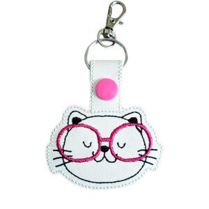 Kitten face keyring with pink glasses, made from white faux leather with a metal split ring and swivel clasp.
