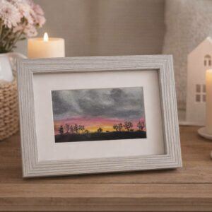 Original oil pastel painting depicting a sunrise under grey heavy skies, with a silhouette of trees below