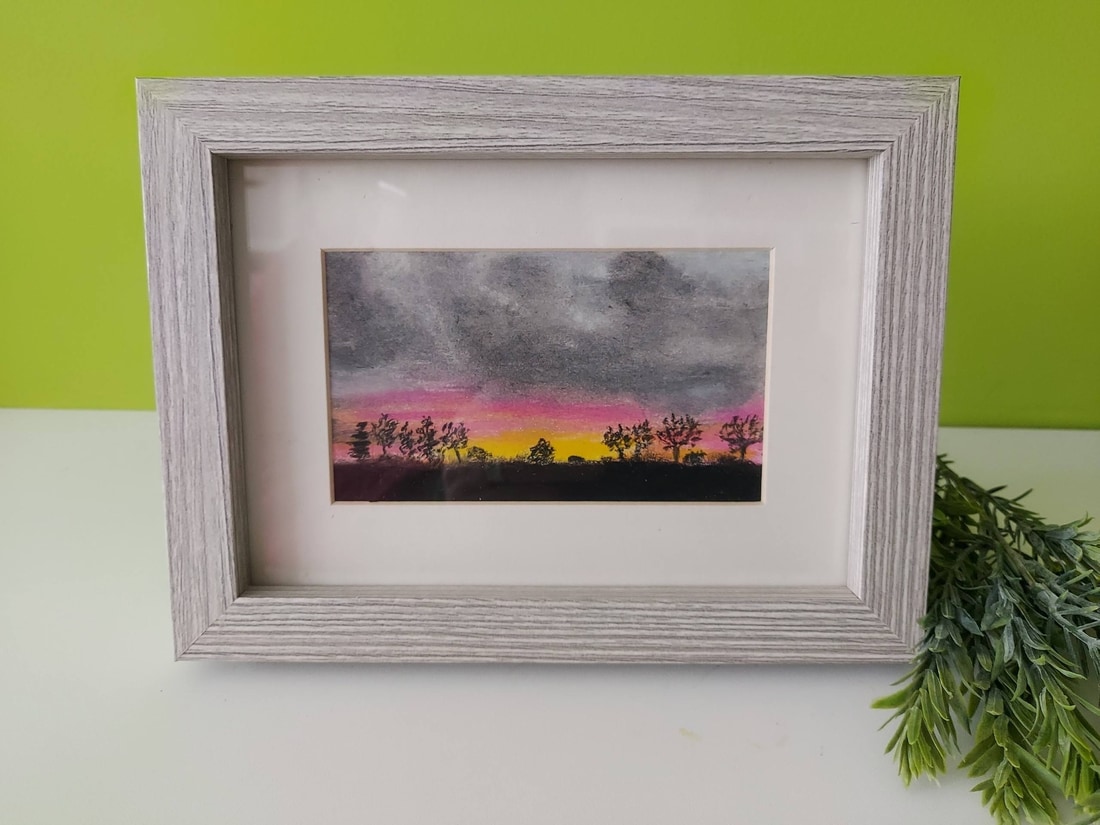 Original oil pastel painting of a sunrise under a moody grey sky with black silhouetted trees