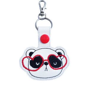 Panda face keyring with red heart glasses, made from white faux leather with a metal split ring and swivel clasp.