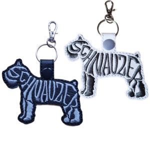 Embroidered Schnauzer word art keyrings in black and white faux leather, featuring stitched dog silhouette design with split ring and lobster clasp