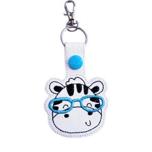 Zebra face keyring with teal glasses, made from white faux leather with a metal split ring and swivel clasp.