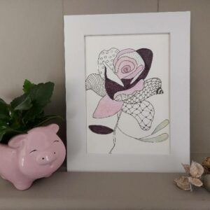 Framed floral illustration on a shelf with a small plant and decorative objects
