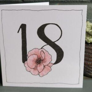 white 5" x 5" 18th birthday card. Black 18 with floral feature