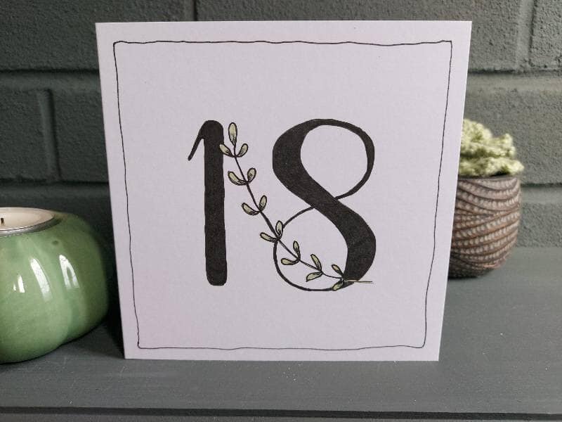 white 5" x 5" 18th birthday card. Black 18 with leaf stem feature