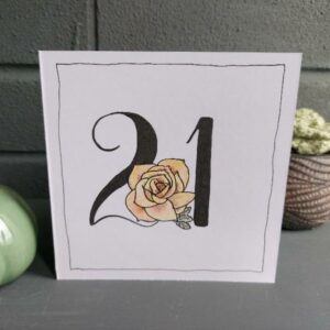 white 5" x 5" 21st birthday card. Black 21 with floral feature