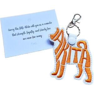 White embroidered Akita word art keyring with silver clip and matching keepsake card for dog lovers.