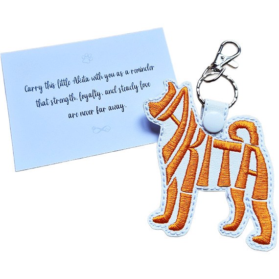 White embroidered Akita word art keyring with silver clip and matching keepsake card for dog lovers.
