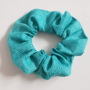 Aqua cotton fabric scrunchie with a subtle textured pattern on a white background.