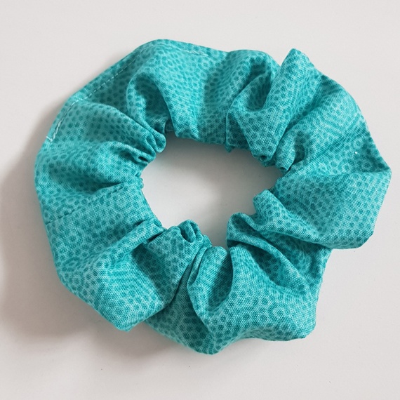Aqua cotton fabric scrunchie with a subtle textured pattern on a white background.