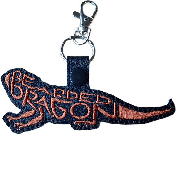 Black faux leather bearded dragon word art keyring with copper embroidered lettering and silver metal lobster clasp.