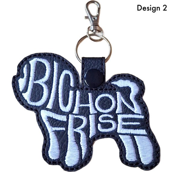 Black faux leather Bichon Frise word art keyring, Design 2, with white embroidered lettering, black snap fastener and silver clip.