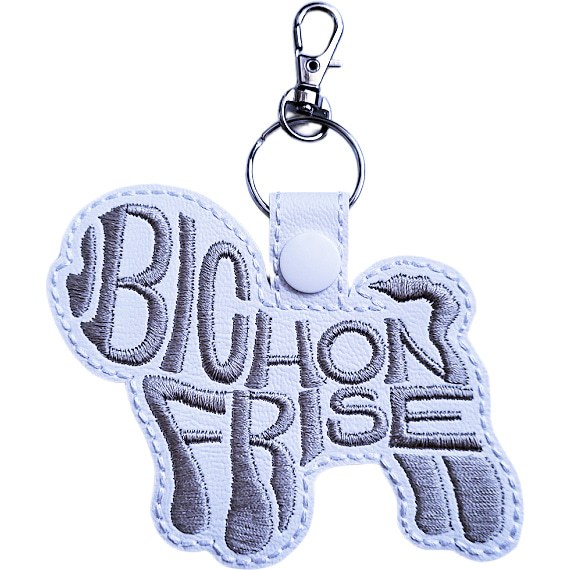 White faux leather Bichon Frise word art keyring, Design 2, with grey embroidered lettering, white snap fastener and silver clip.