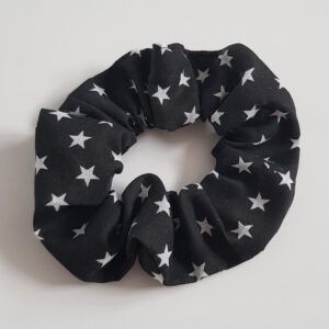 Black fabric hair scrunchie with white star print on a light background.