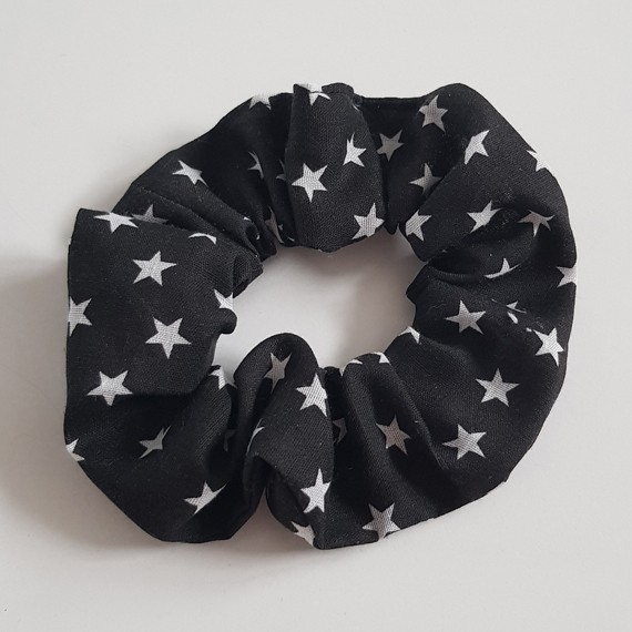 Black fabric hair scrunchie with white star print on a light background.