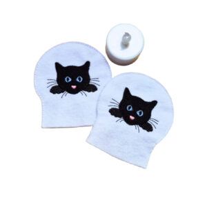 Embroidered cat LED tealight covers on white felt, with black cat faces and bright stitched details, shown beside a battery operated tealight.