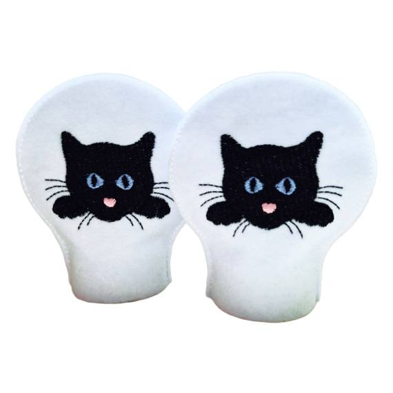 Unlit embroidered cat LED tealight covers on white felt, with black cat faces, blue stitched eyes and pink noses, designed to fit over battery operated tealights.
