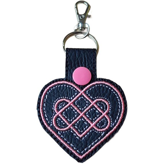 Black Celtic Heart keyring with pink and white embroidered heart knot design, pink snap and silver metal clasp.