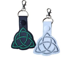 Black and white Celtic Triquetra keyrings with embroidered knotwork designs and silver metal clasps.