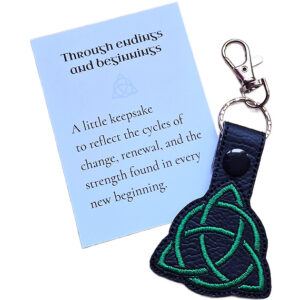 Black Celtic Triquetra keyring with green embroidered knotwork design, shown with a matching keepsake card about endings, beginnings and renewal.