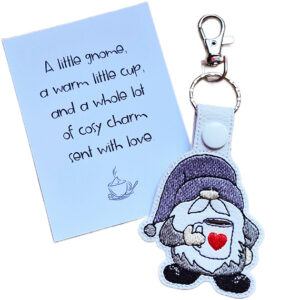 Embroidered coffee gnome keyring shown beside a matching keepsake card with a cosy coffee gift message.