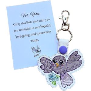 Embroidered purple kawaii bird keyring with flower detail, silver clip and matching keepsake card with hopeful bird-themed message.