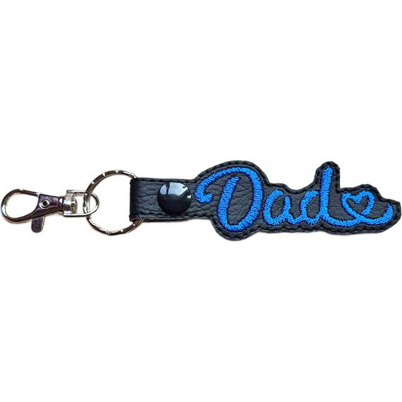 Black faux leather Dad Heart keyring with blue embroidered Dad lettering, heart detail and sturdy metal keyring hardware.