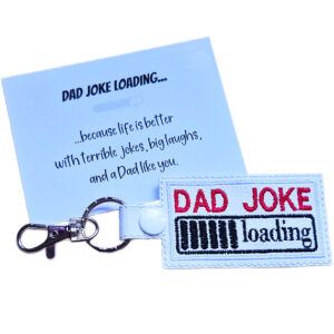 Black faux leather Dad Joke Loading keyring with colourful embroidered loading bar design, shown with a funny keepsake card for Dad.