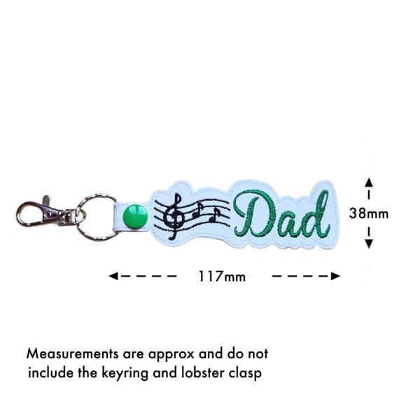 Size guide for white Dad Music Note keyring showing approximate measurements of 38mm x 117mm, excluding the keyring and lobster clasp.