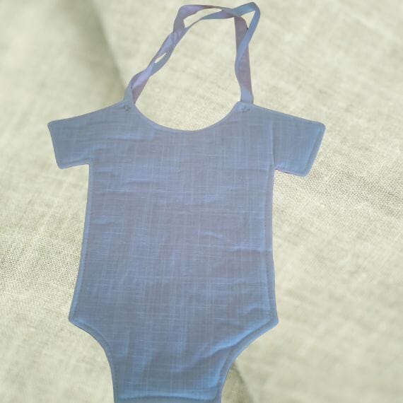 Decorative Nursery Item with white backing pink and white ribbon hangers. The pink ribbon has a greeting "it's a girl"