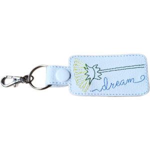White faux leather dandelion keyring with embroidered flower design, stitched 'dream' wording, white snap fastener and silver keyring clip.