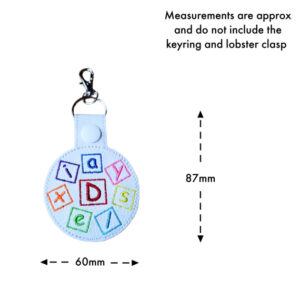 Size guide for colourful embroidered Dyslexia Awareness keyring, showing approximate measurements of 87mm high by 60mm wide, not including the keyring or lobster clasp.