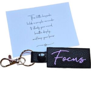 Embroidered Focus keyring in black faux leather, shown beside a matching keepsake card with a motivational message about staying focused.