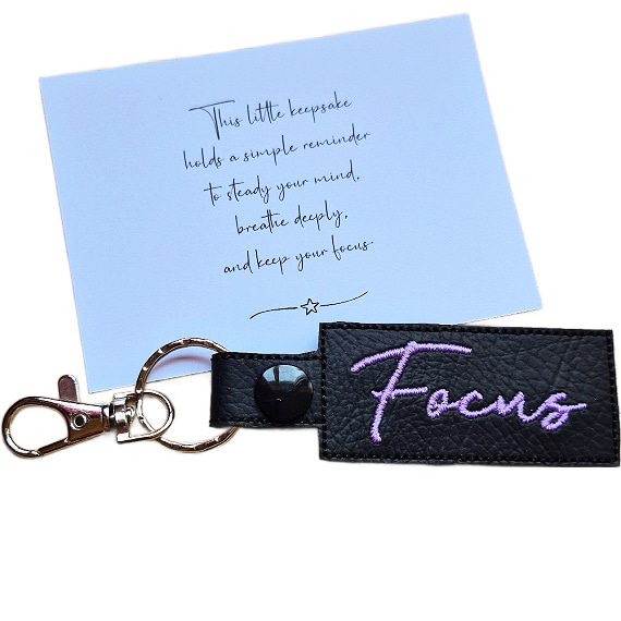 Embroidered Focus keyring in black faux leather, shown beside a matching keepsake card with a motivational message about staying focused.