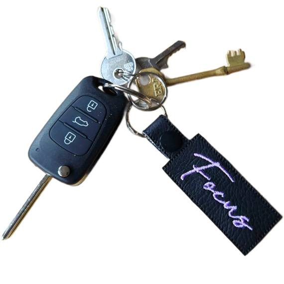 Embroidered Focus keyring attached to a set of keys, featuring black faux leather and the word 'Focus' stitched in lilac.