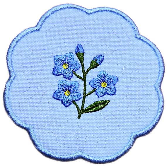 Close up of an embroidered forget me not candle coaster with blue flowers, green leaves, yellow centres and a soft blue scalloped border.