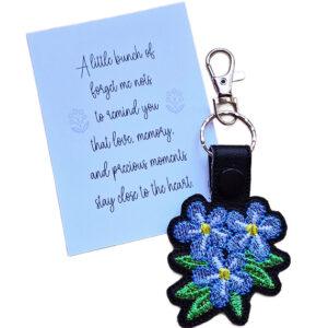 Embroidered forget me not flower keyring with a pale blue keepsake card, featuring a meaningful remembrance message about love, memory and precious moments.