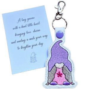 Embroidered girl gnome keyring with a purple hat and pink dress, shown beside a matching keepsake card with a kind-hearted gnome gift message.