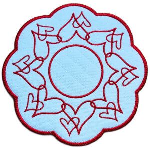 Close up of an embroidered heart candle mat with flowing red heart designs, circular centre and rich red scalloped border.