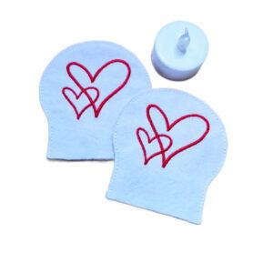 Two embroidered heart tealight covers made from white felt, shown with an LED tealight for display.
