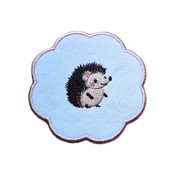 Embroidered hedgehog candle coaster with a cute stitched hedgehog in the centre, scalloped edging and a soft woodland style design.