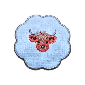Embroidered Highland cow candle coaster with a sweet stitched Highland cow in the centre, scalloped edging and soft countryside style detailing.