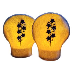 Lit embroidered July birth flower tealight covers on white felt, glowing warmly with purple larkspur designs over battery operated LED tealights.
