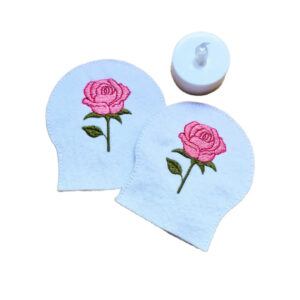 Embroidered June birth flower tealight covers on white felt, with pink roses and green leaves, shown beside a battery operated LED tealight.