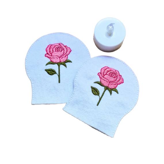 Embroidered June birth flower tealight covers on white felt, with pink roses and green leaves, shown beside a battery operated LED tealight.
