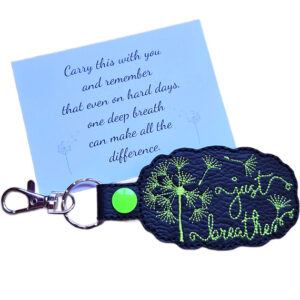 Black embroidered 'just breathe' dandelion keyring with silver clip and matching keepsake card with calming reminder message.