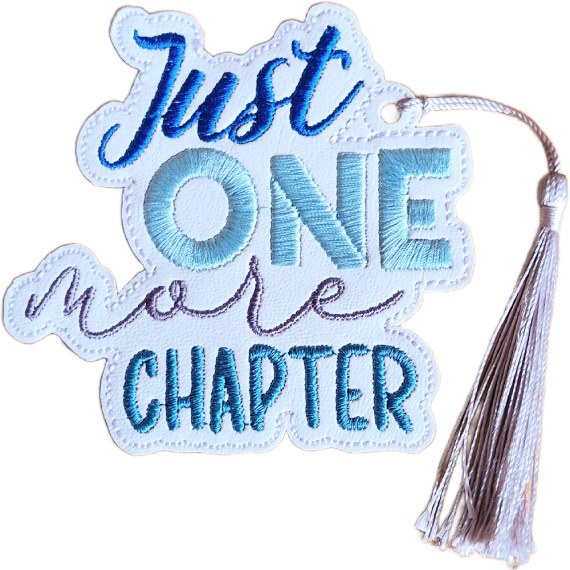 Embroidered 'Just One More Chapter' bookmark on white faux leather with blue and lilac stitched wording and a coordinating tassel.